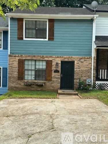 A blue house with a black door and a window with brown shutters.
