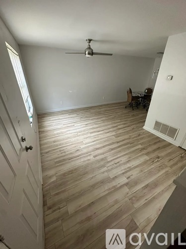 A room with wooden flooring and a ceiling fan.
