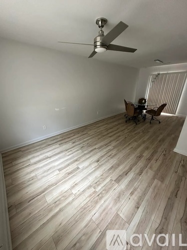 A room with wooden flooring and a ceiling fan.
