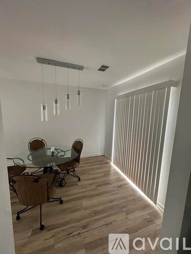 A dining room with a glass table and chairs.