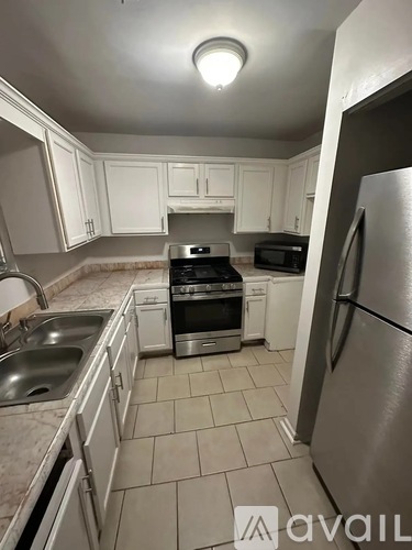 A kitchen with a stainless steel refrigerator, sink, and oven.