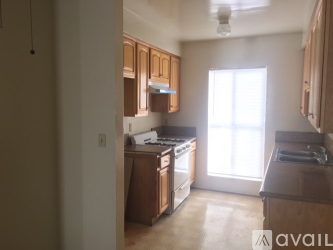 A kitchen with wooden cabinets and a window letting in natural light.