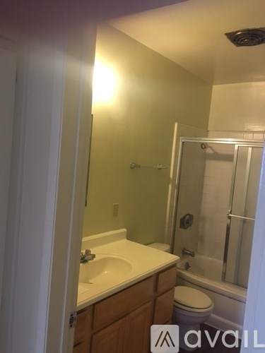 A bathroom with a toilet, sink and shower.