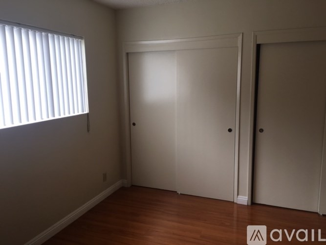 A room with a white door and a window with blinds.