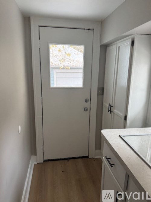 A white door with a window in the middle of it.