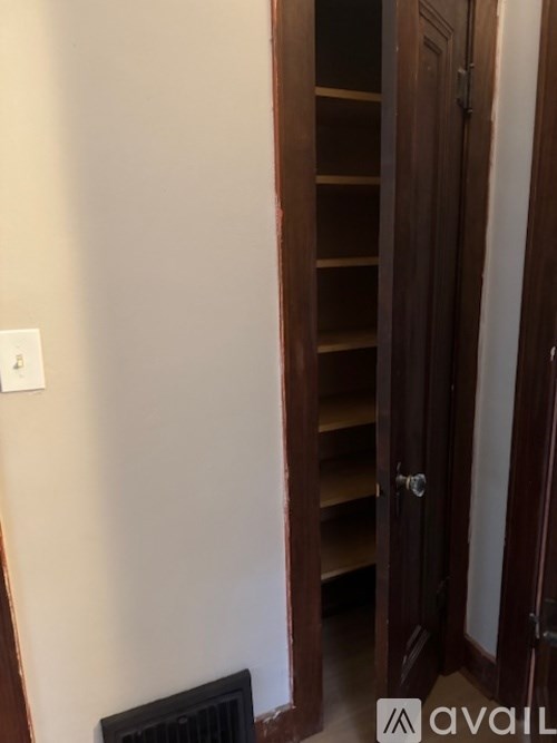 A tall wooden closet door is open.