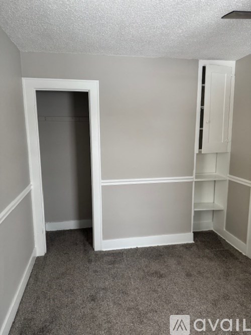 A small, empty room with a doorway leading to another room.