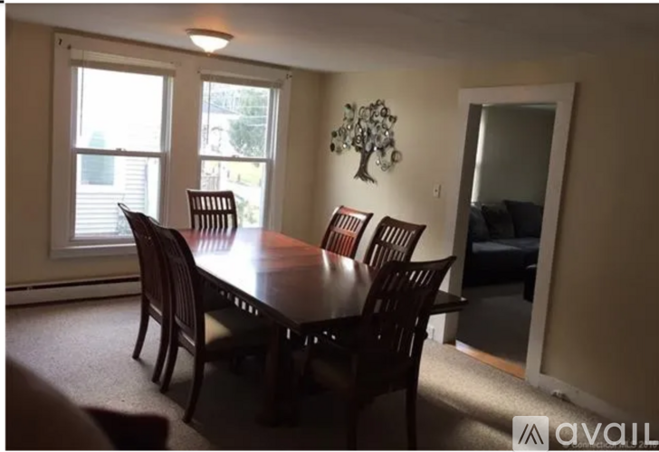 A dining room with a table and chairs.