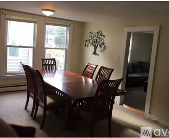 A dining room with a table and chairs.