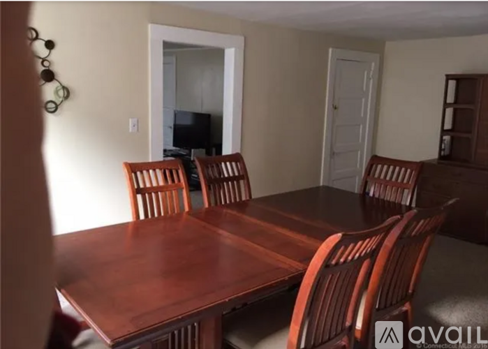 A wooden dining table with chairs in a room.