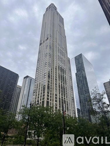 A tall building with many windows stands in front of other buildings.
