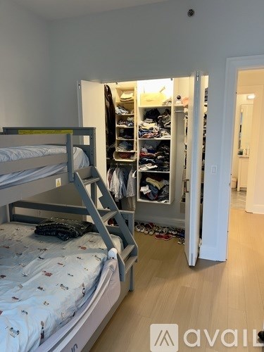A bedroom with a bed and an open closet.