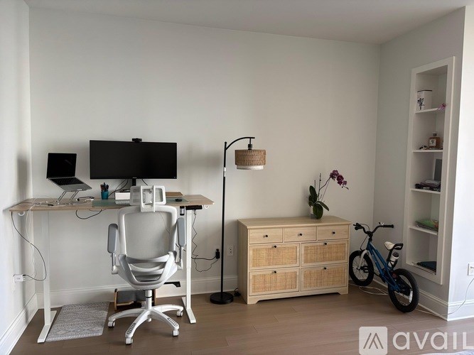 A room with a desk, chair, and a bicycle.