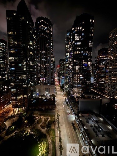 A cityscape at night with tall buildings and a dark sky.