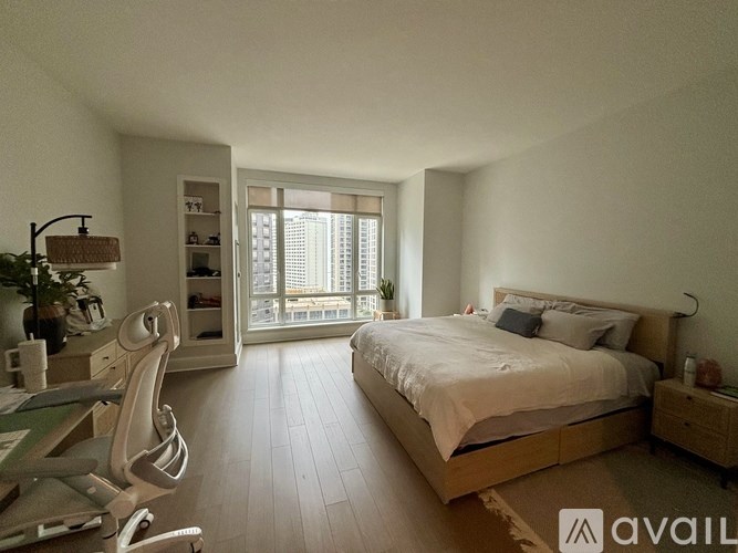 A bedroom with a large bed and a desk with a chair.