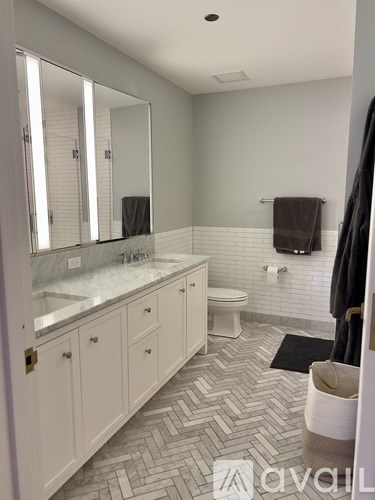 A bathroom with a marble counter top and a white toilet.