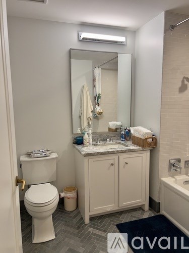 A bathroom with a toilet, sink, and mirror.