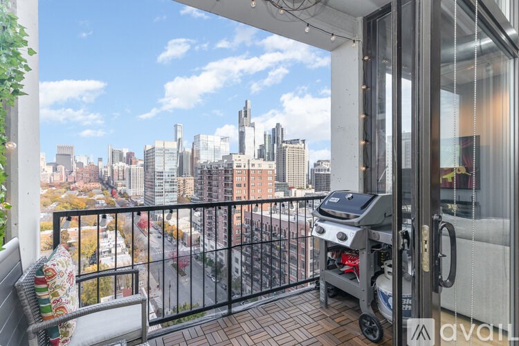 A balcony with a grill and a view of a city skyline.