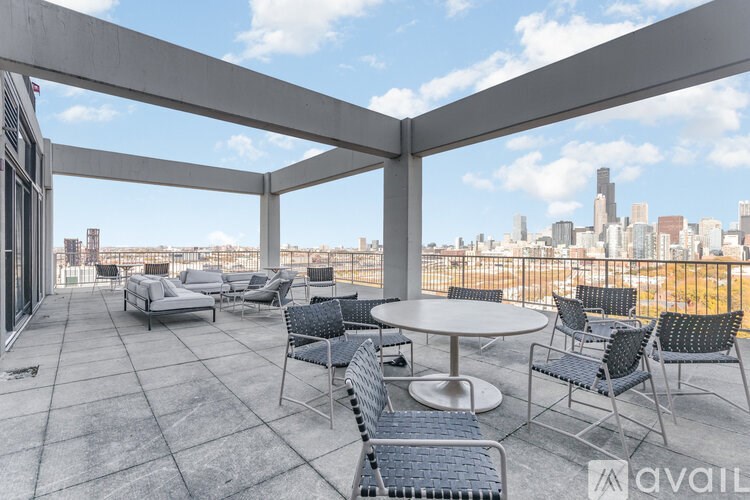 A balcony with a table and chairs overlooking a city skyline.