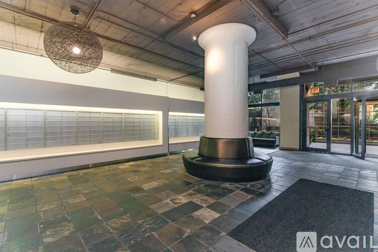 A large white column stands in the middle of a lobby with a black and white checkered floor.