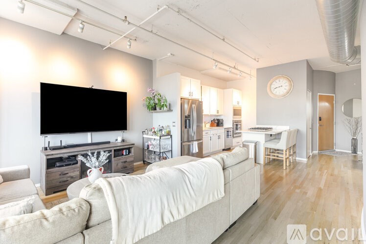 A living room with a white couch and a flat screen TV.