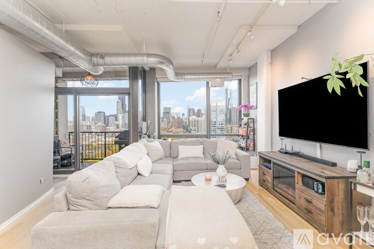 A living room with a grey sofa and a wooden entertainment center.
