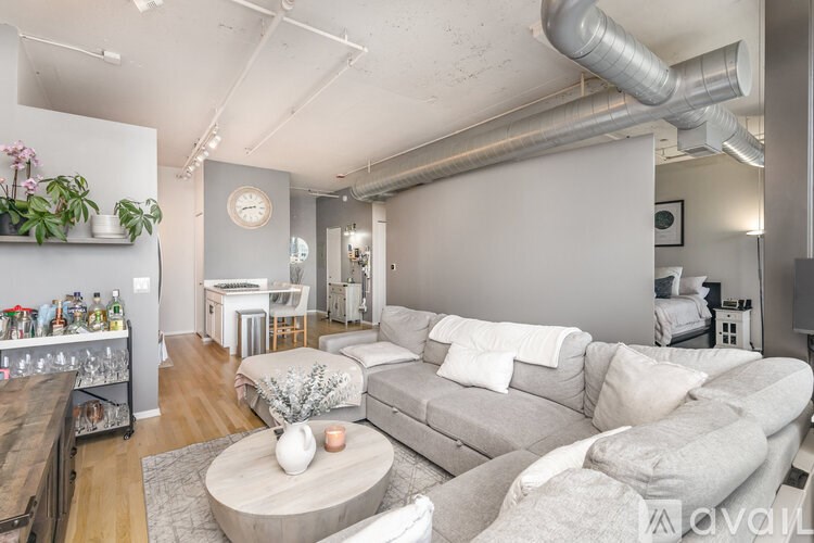 A living room with a grey couch and a wooden coffee table.