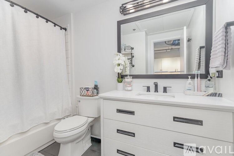 A white bathroom with a toilet, sink, and mirror.
