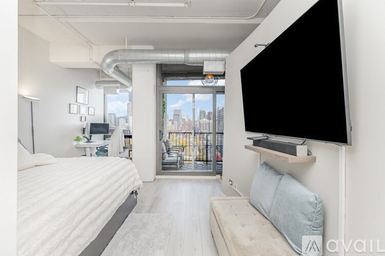 A bedroom with a large bed and a flat screen TV mounted on the wall.