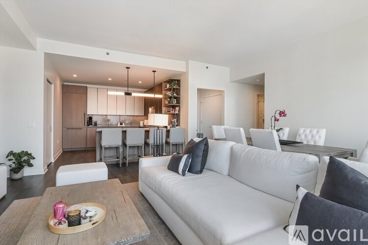 A modern living room with a white sofa and a wooden coffee table.
