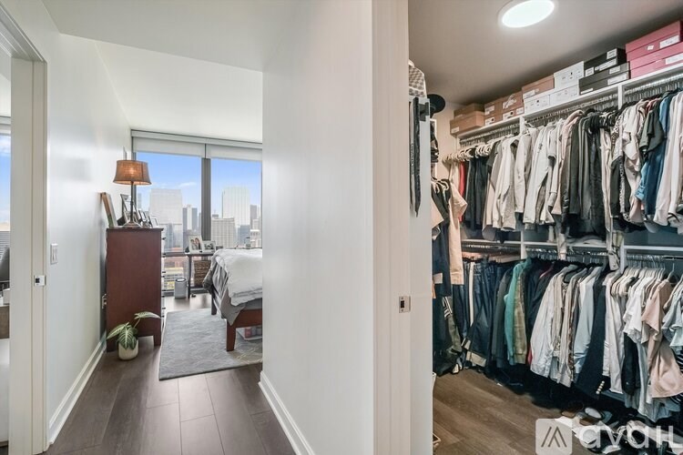 A room with a large closet and a bed in the background.