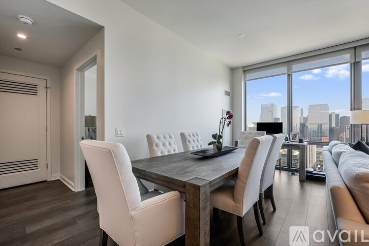 A modern dining room with a wooden table and white chairs.
