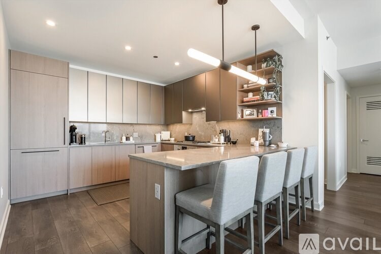 A modern kitchen with a center island and bar stools.
