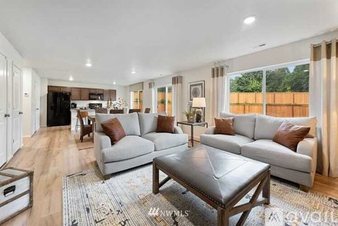A spacious living room with a grey sofa set and a wooden coffee table.