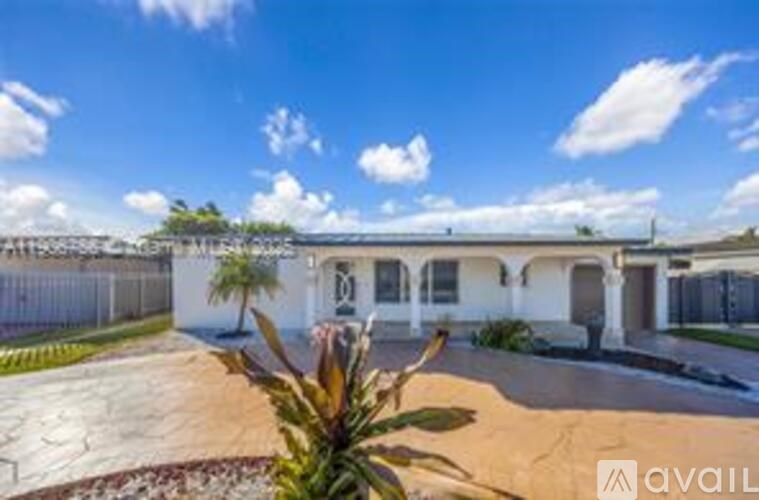 A white house with a palm tree in front of it.