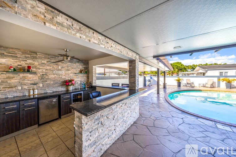 A stone bar area with a pool in the back.