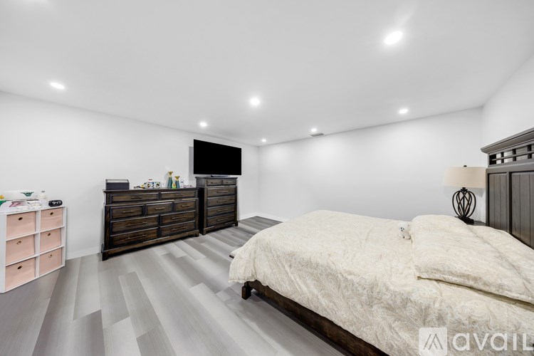 A bedroom with a bed, dresser, and TV.