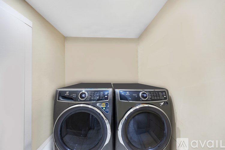 Two front load washing machines in a small laundry room.
