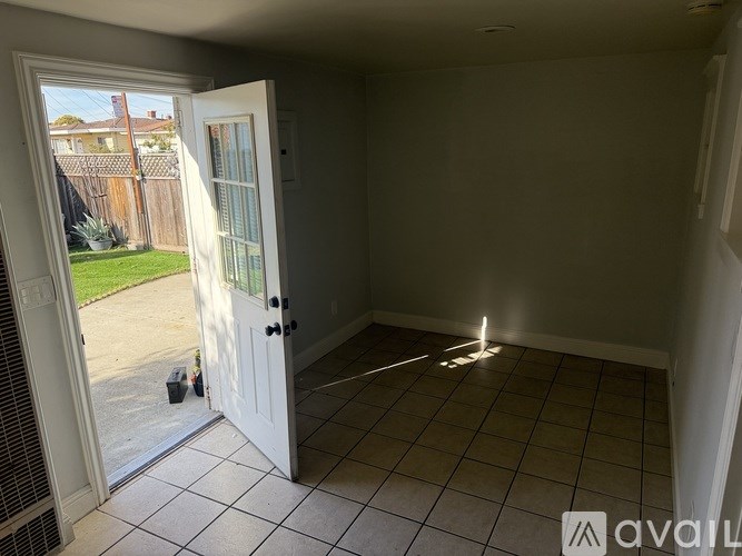 A room with a white door and tiled floor.
