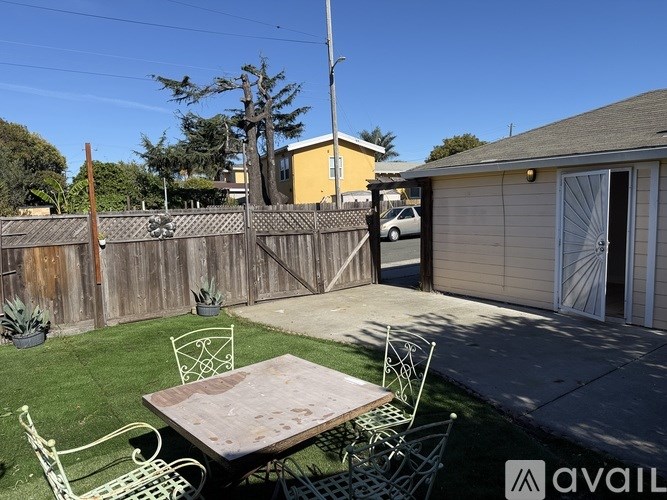 A backyard with a wooden table and chairs.