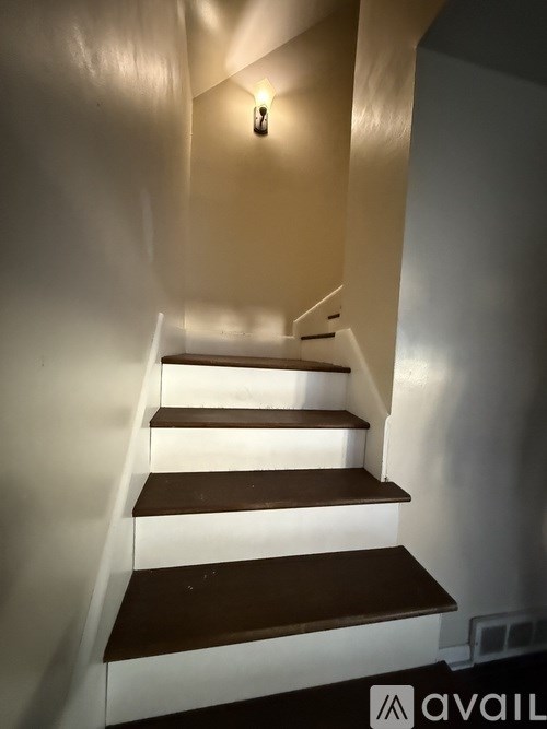 A staircase with white risers and dark brown treads.