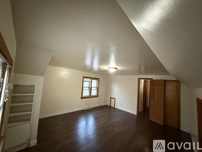 A spacious room with wooden floors and a window.
