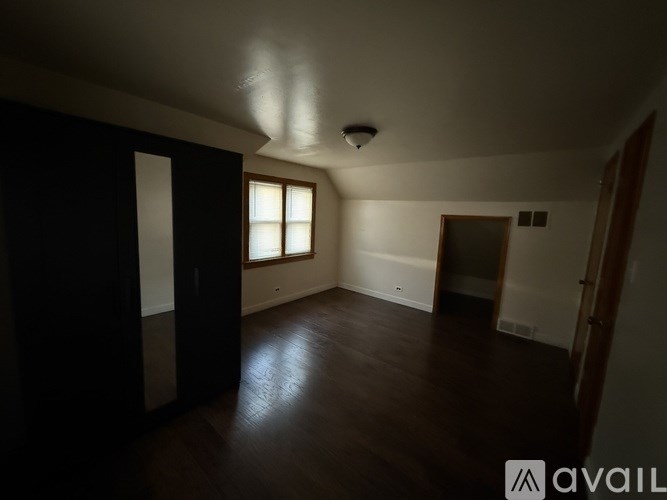 A spacious room with wooden floors and a window.