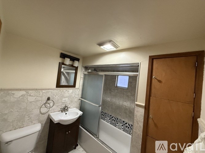 A bathroom with a white sink and a glass shower stall.