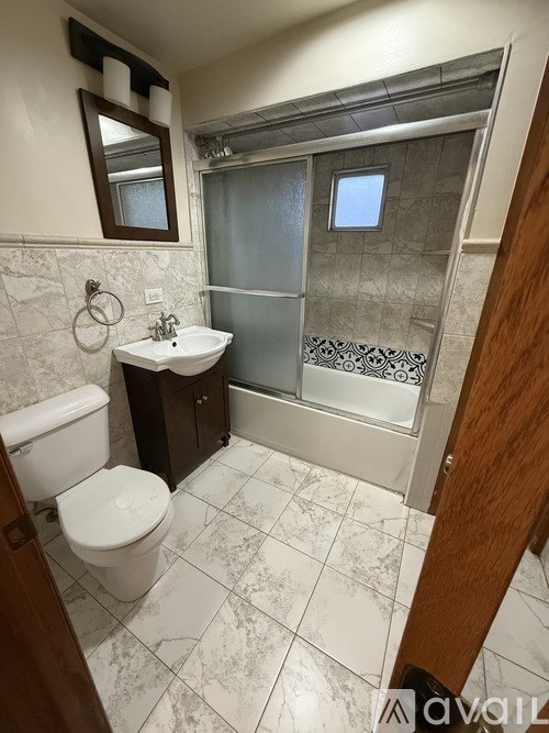 A bathroom with a toilet, sink, and shower.