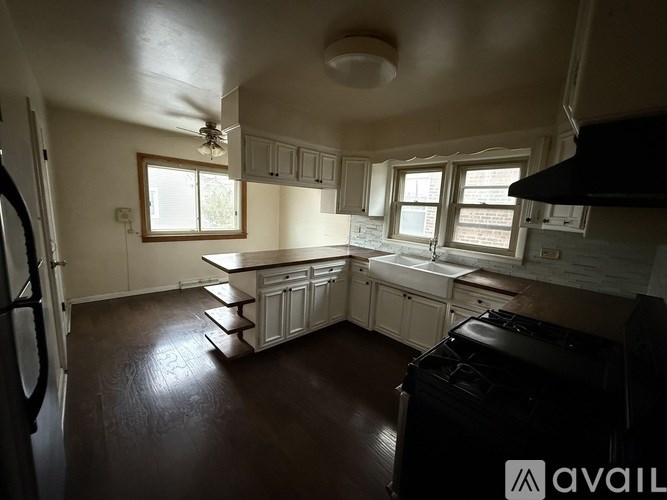 A kitchen with white cabinets and a black stove top oven.