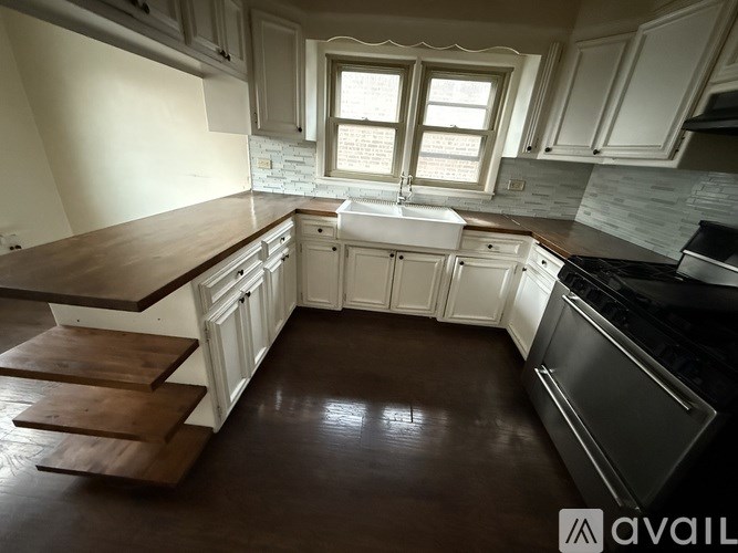 A kitchen with white cabinets and a window above the sink.