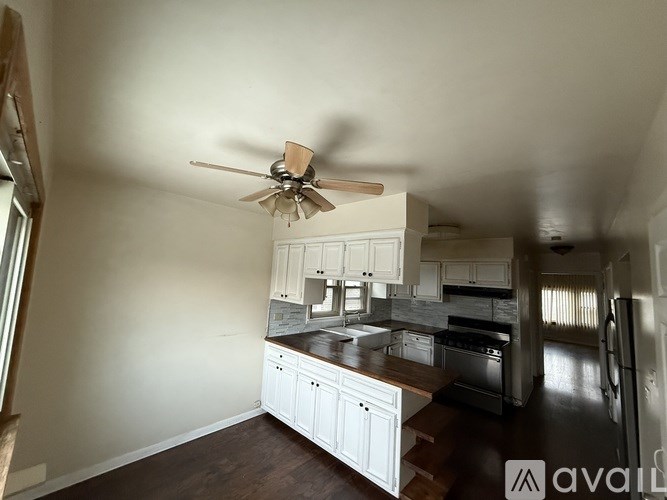 A kitchen with white cabinets and a wooden island.