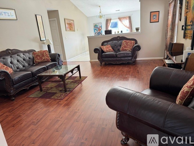 A living room with a black couch and a black chair.