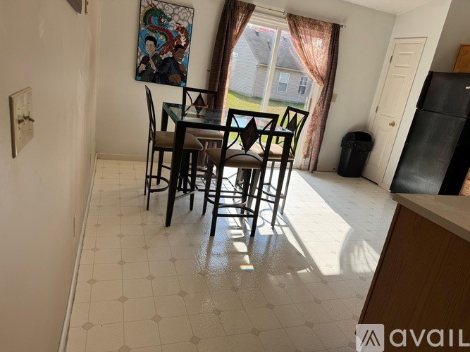 A dining room with a table and chairs.